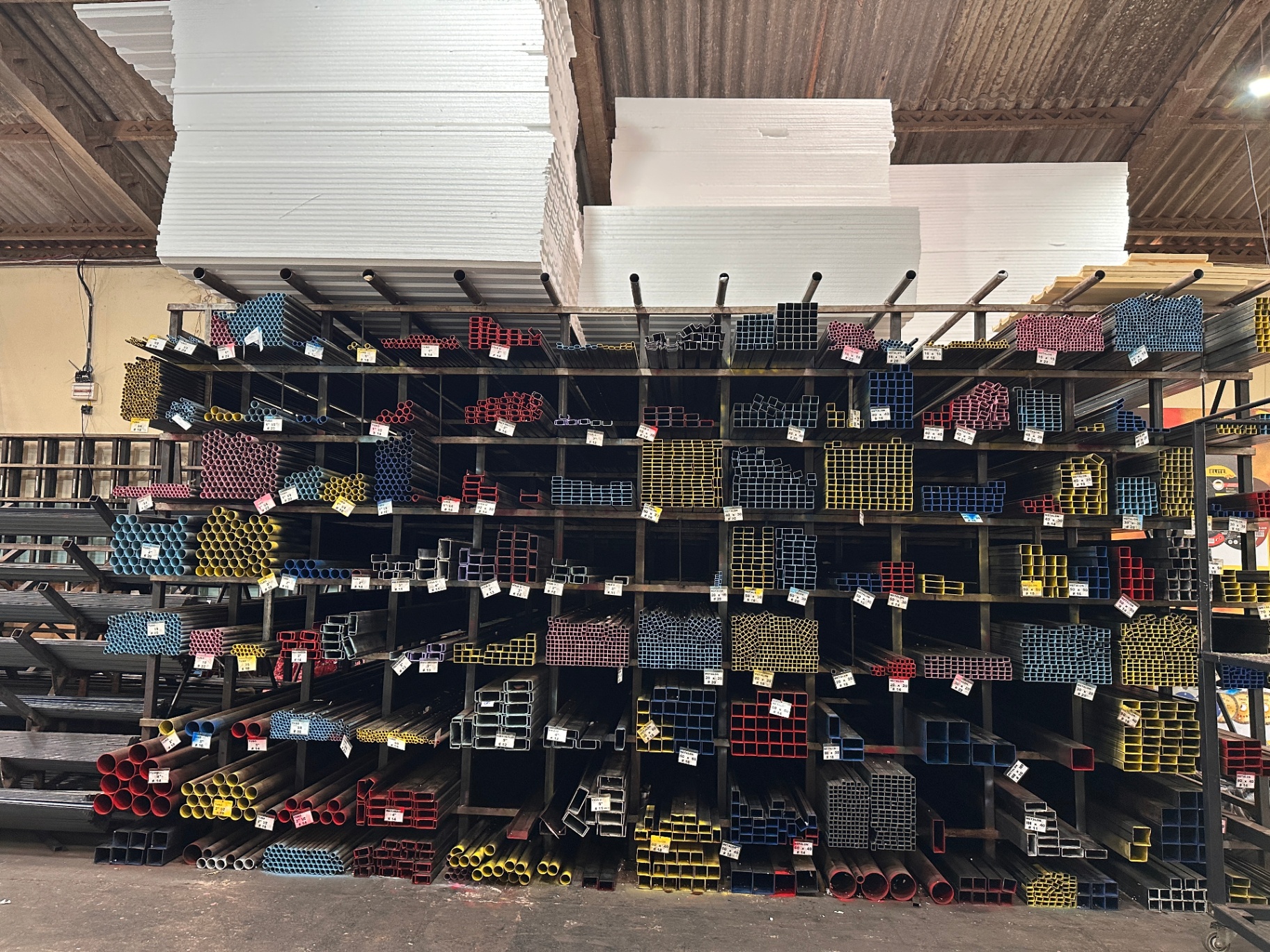 Telhas metálicas e materiais organizados no interior do Grupo Londriaço.